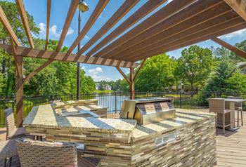 a patio with a grill and a table and chairs